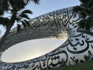 Dubai's Museum of the Future shown as a metal oval with Arabic writing on its surface.