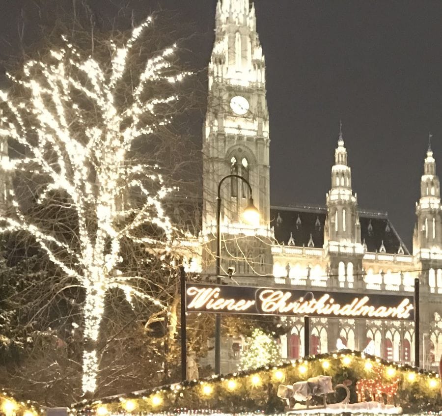 Tall lit-up building with a sign that says "Wiener Criskindelmarkt"