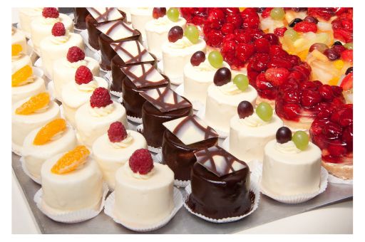 Many colorful, small bite-sized cakes on display.