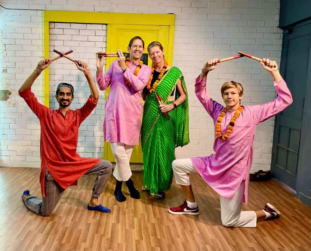 5 people posing at the end of a dance, on wooden floors, in front of a white wall while taking Bollywood Dancing Lessons in Delhi.