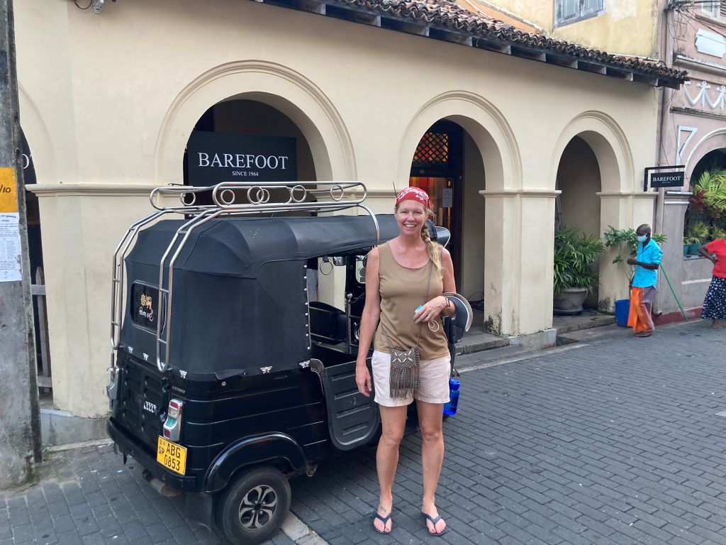 Woman standing in front of a tuk tuk in Sri Lanka