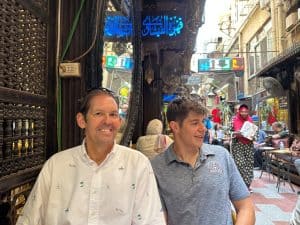 Two men sitting at a cafe on a busy pedestrian alley in Cairo Egypt.