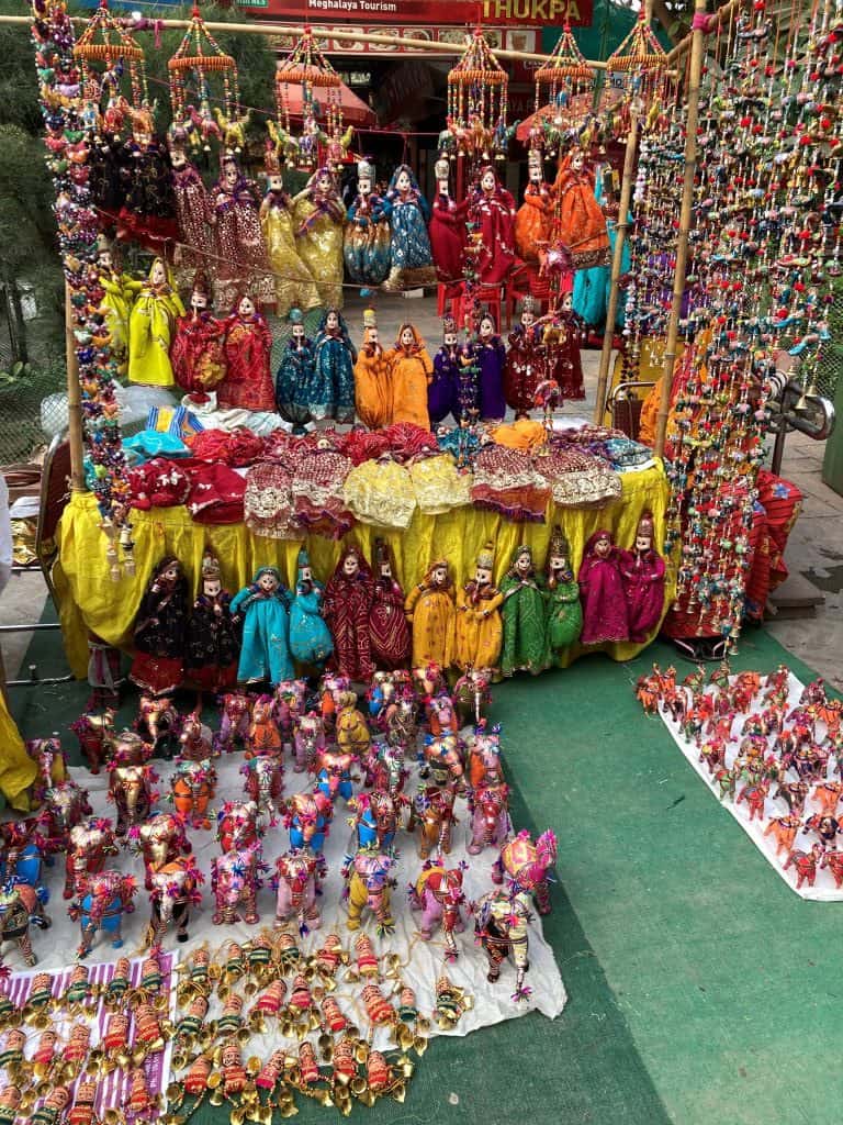 Many small colorful textile items for sale at an outdoor market in India.