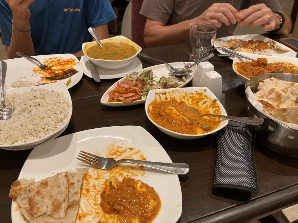 Several plates and bowls with traditional Indian food on them at a restaurant in New Delhi, India.
