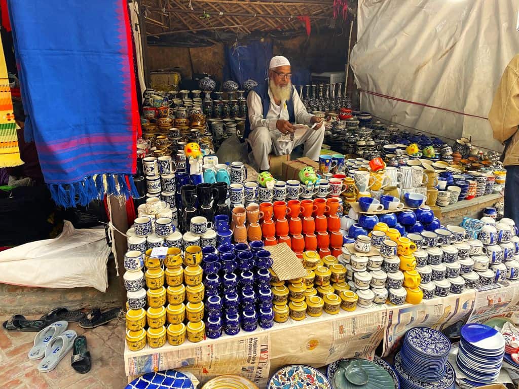 Man sitting behind his display of Indian handicrafts for sale at a market in New Delhi.