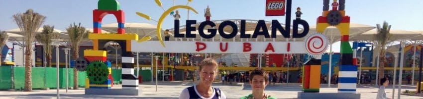 A mother and her son stand in front of the Legoland Dubai entrance.