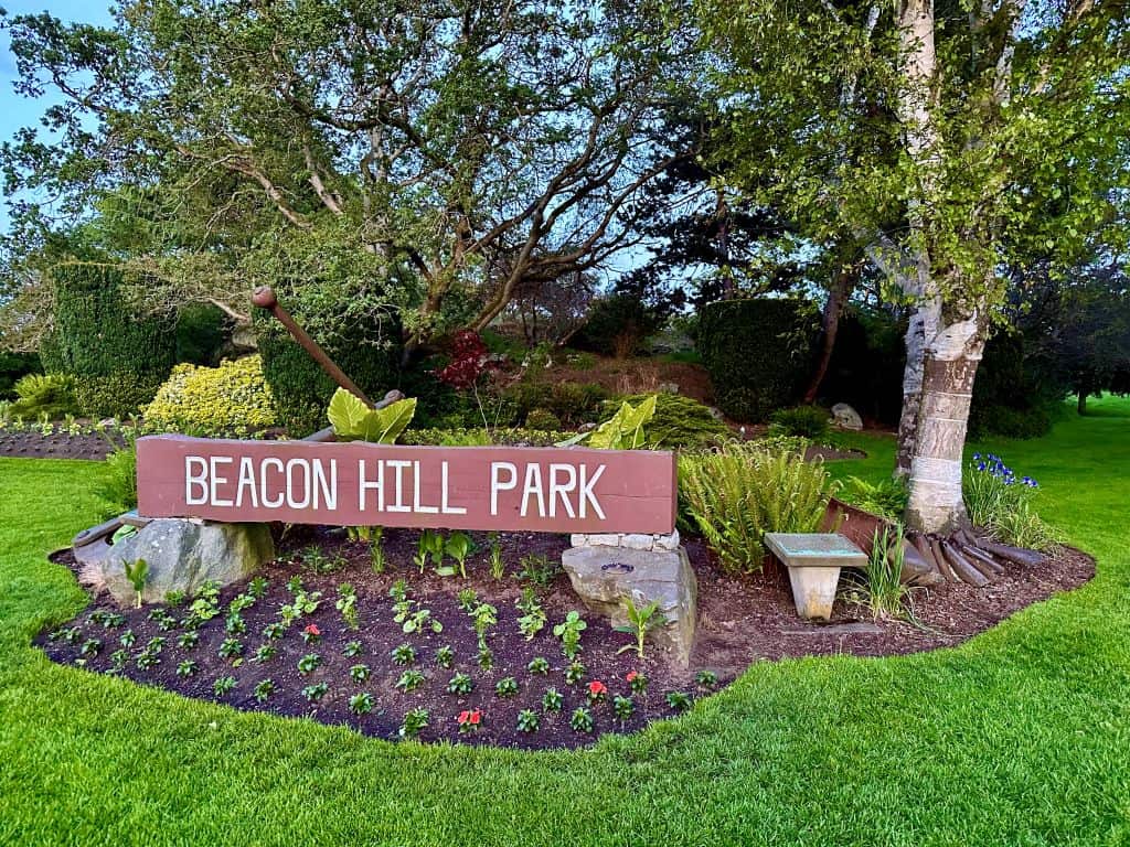 The entrance to a city park. A large sign with bold white letters reads "Beacon Hill Park."