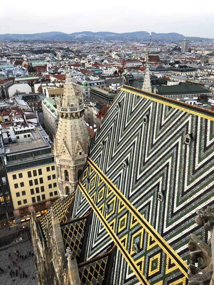 Vienna, as seen from the top of St. Stephen's Cathedral which has a colorful, geometric design on its roof.