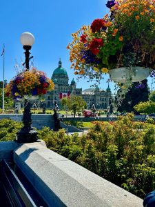 Victoria's Parliament Buildings with green parks and flowers in the foreground.
