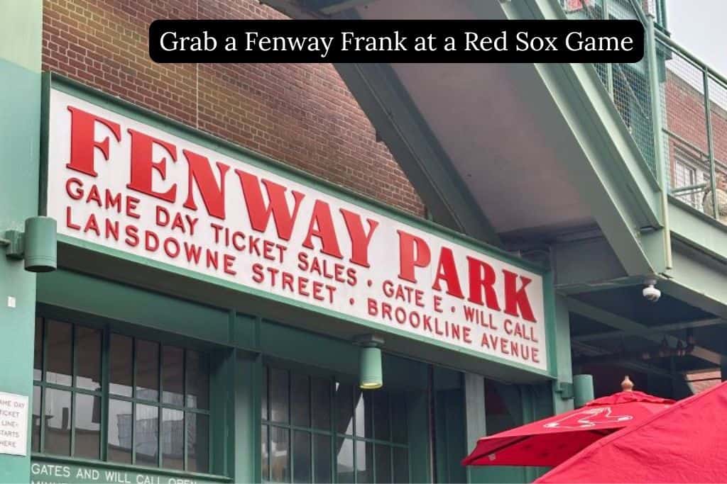 Entrance to Fenway Park with the sign visible, featuring text encouraging visitors to grab a Fenway Frank at a Boston Red Sox game.
