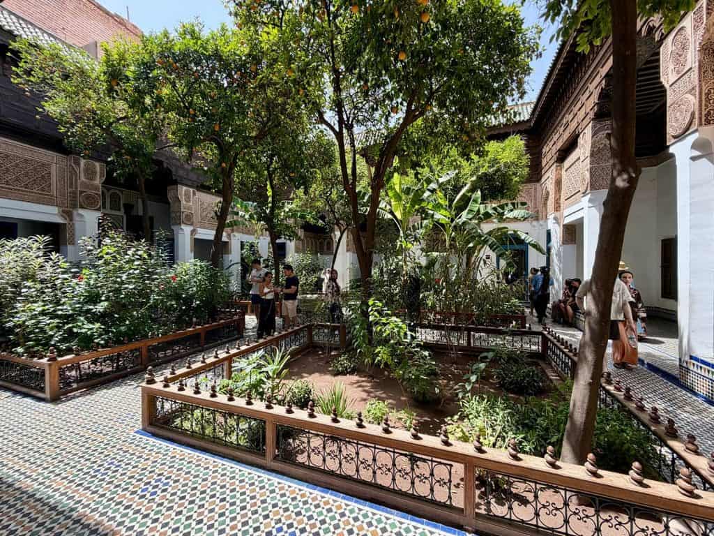 Garden courtyard with colorful tilework at Bahia Palace in Marrakech, Morocco.