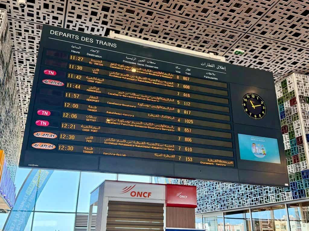 Train departure board at Casablanca Voyageurs station in Morocco showing trains to Marrakech, Fes, Tangier and other destinations.