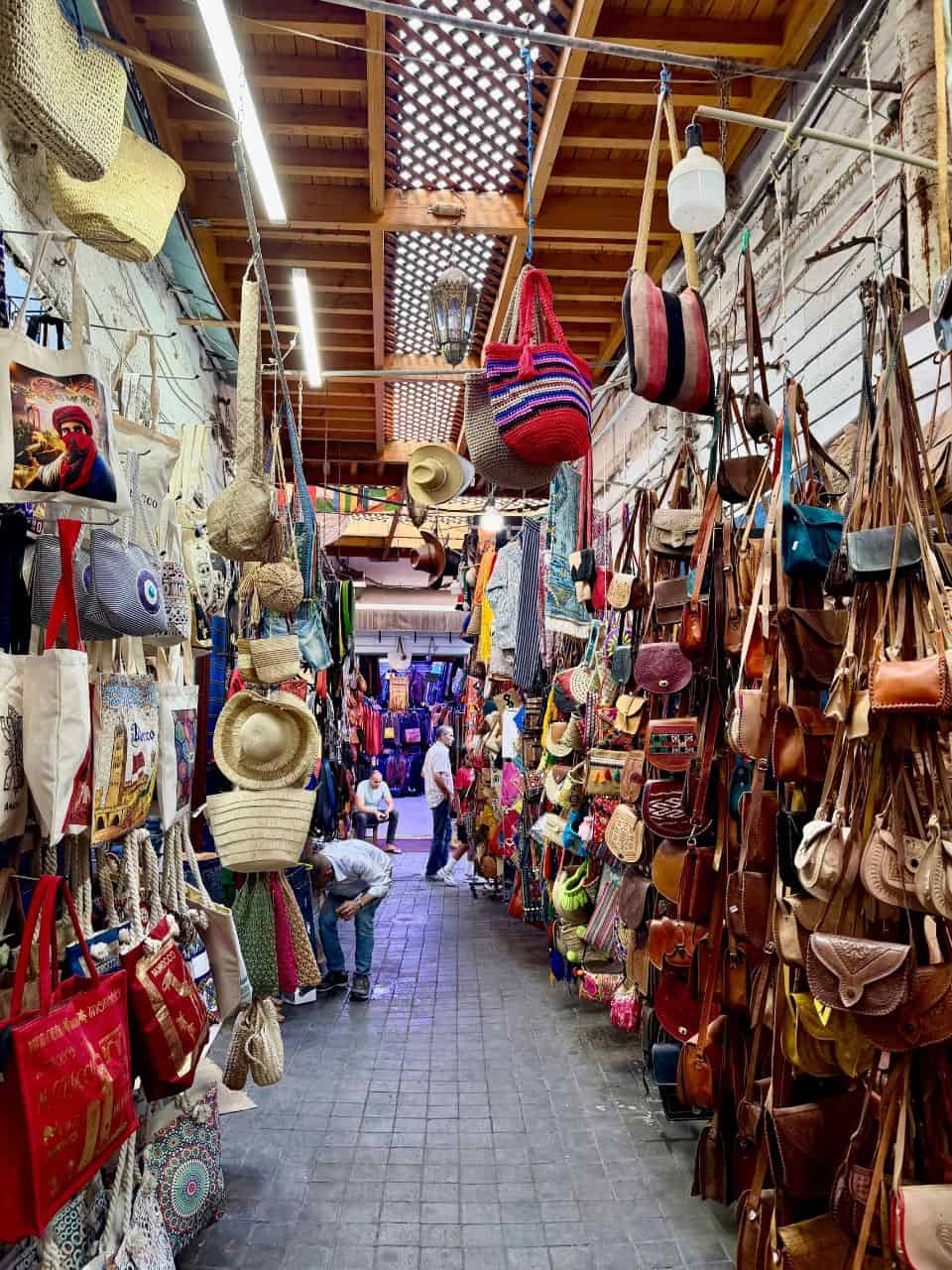Colorful bags and leather goods lining a narrow passage in Casablanca's old medina in Morocco
