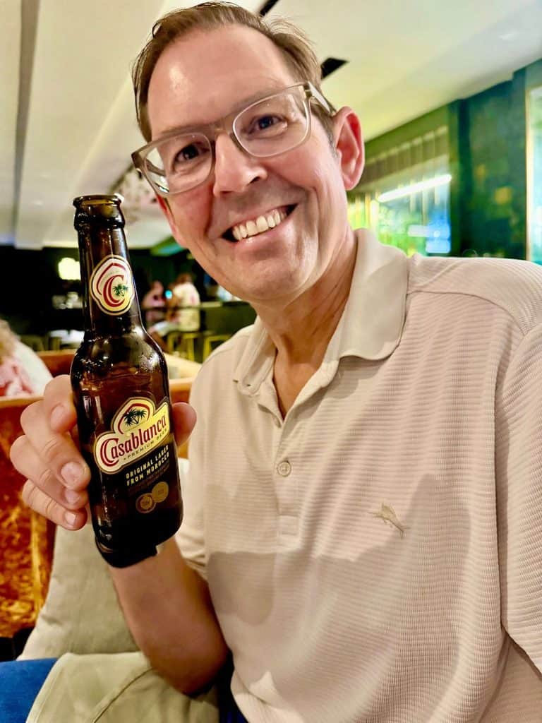 Man holding a Casablanca beer at a rooftop restaurant in Casablanca, Morocco.