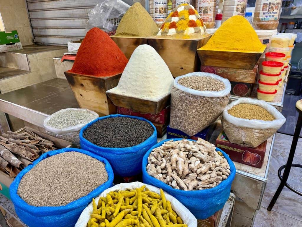 Colorful spices, grains and dried ingredients displayed in the Meknes medina in Morocco.