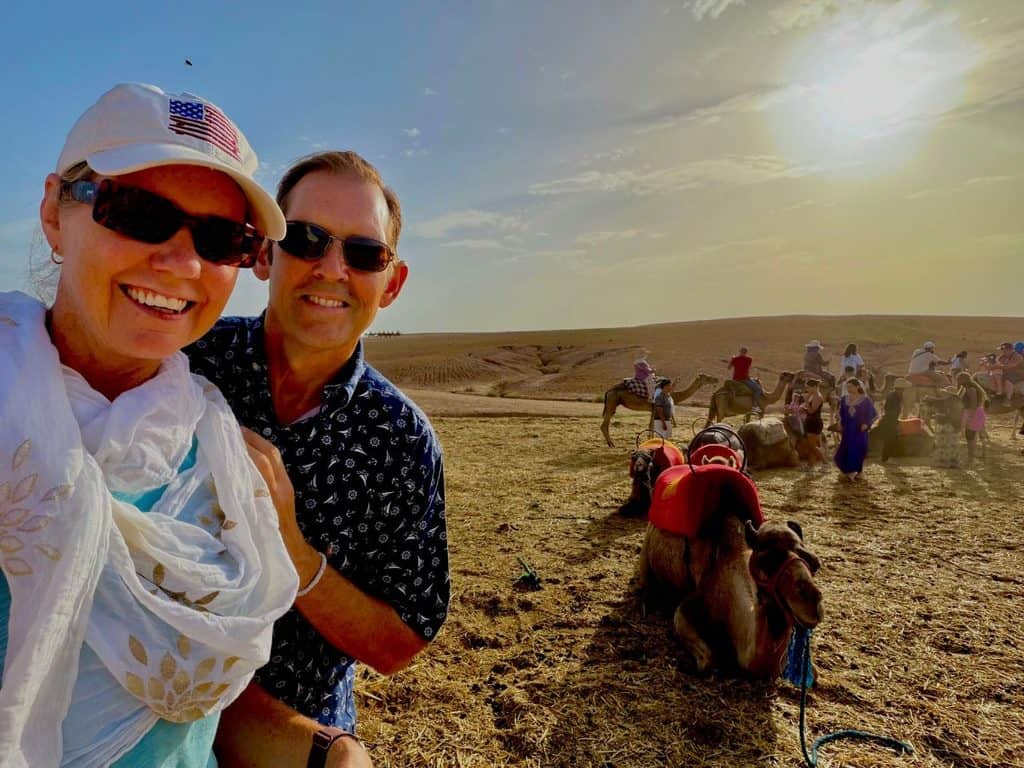 Couple visiting the Agafay Desert near Marrakech during a camel ride excursion in Morocco.