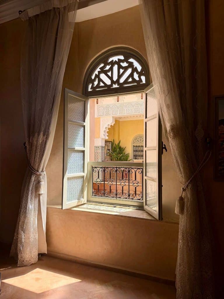 Open window overlooking the courtyard from a guest room in a traditional riad in Meknes, Morocco.